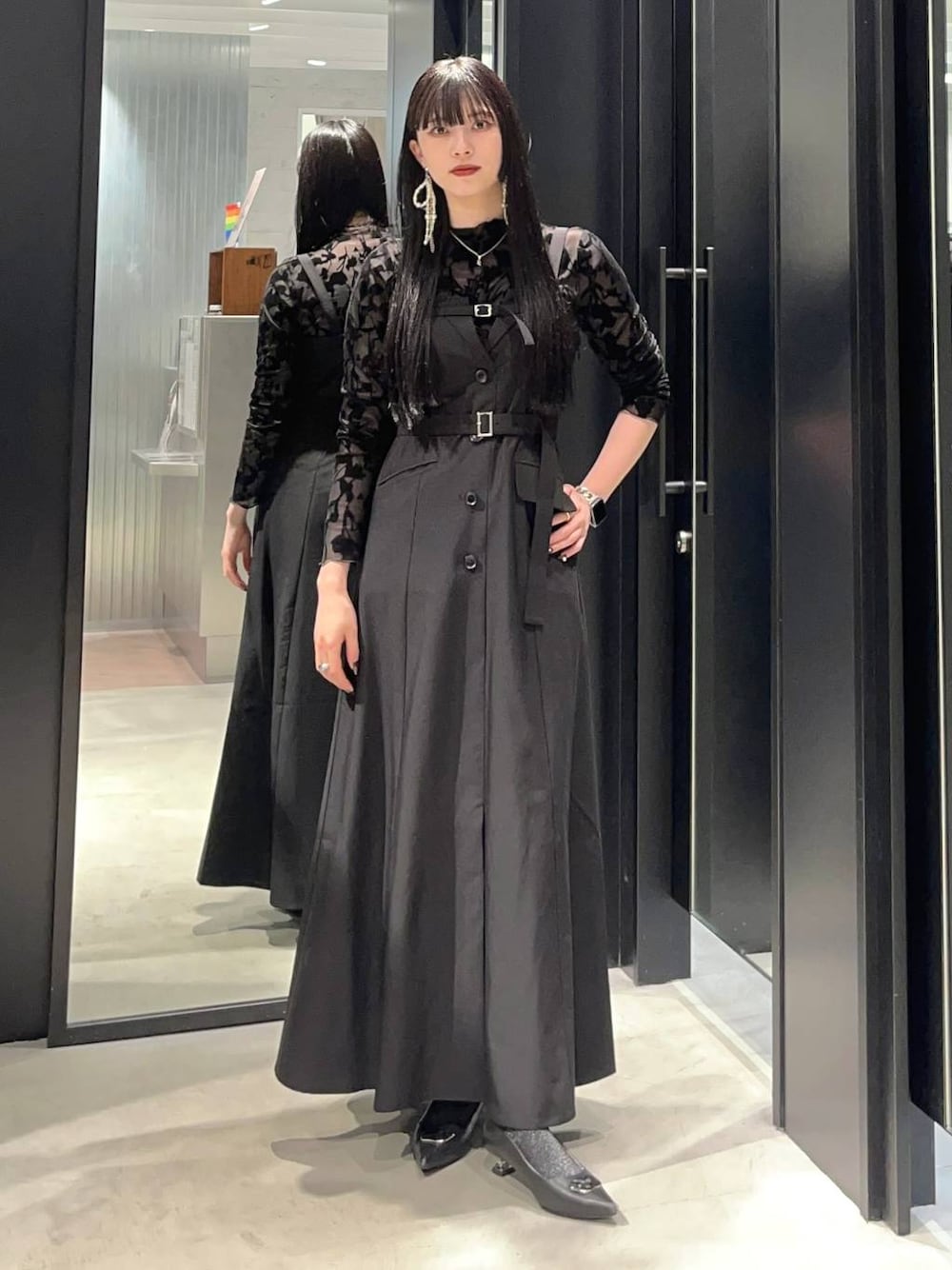 ブラック系のジャンパースカート、シルバー系のパンプス、シルバー系のピアス（両耳用）を着用したレディースの夏コーディネートの1枚目の写真