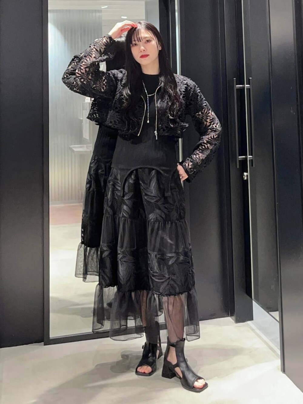 ブラック系のTシャツ/カットソー、ブラック系のサンダル、ブラック系のスカートを着用したレディースの春コーディネートの1枚目の写真