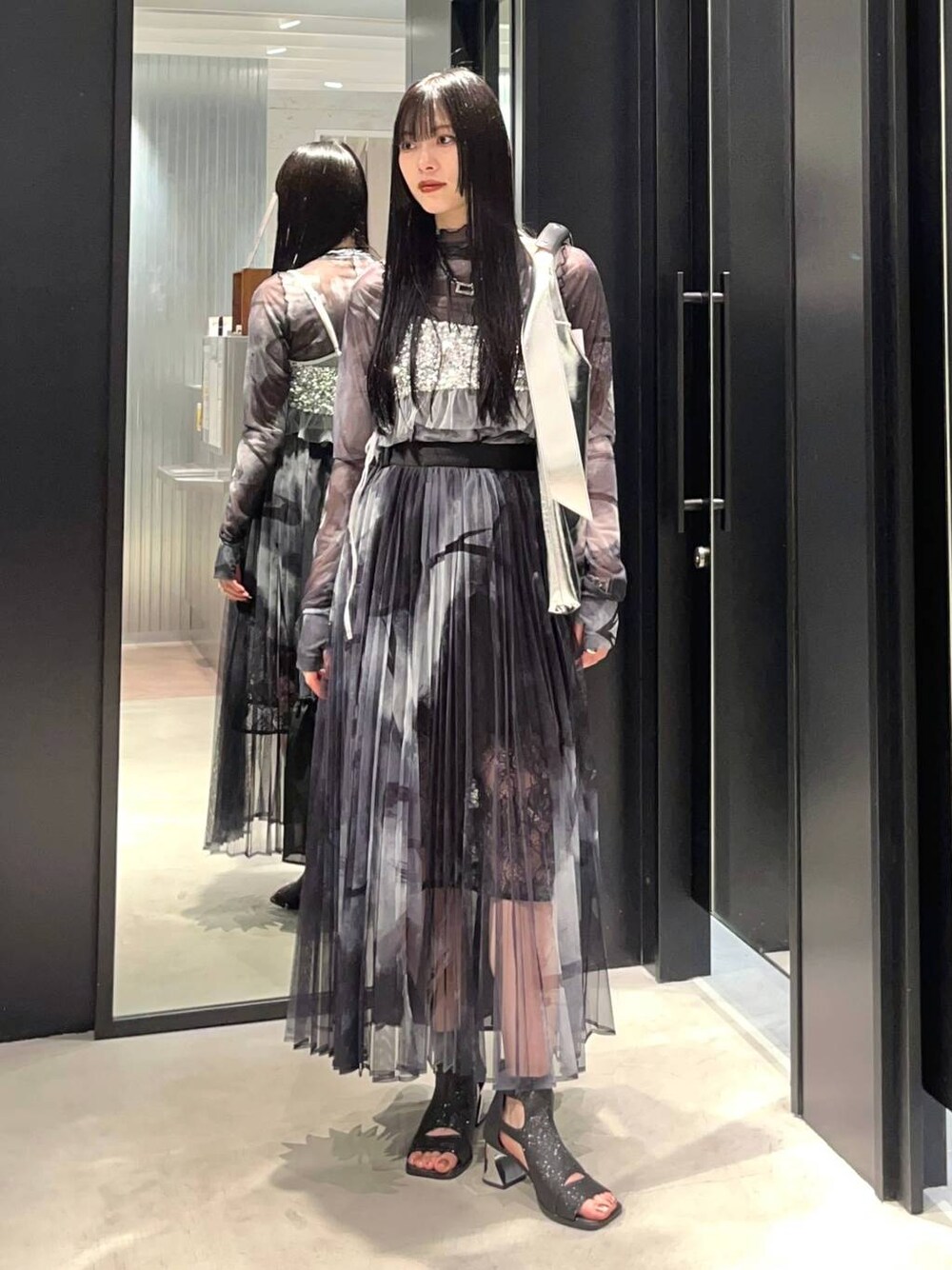 シルバー系のチューブトップ、ブラック系のサンダル、シルバー系のトートバッグを着用したレディースの春コーディネートの1枚目の写真