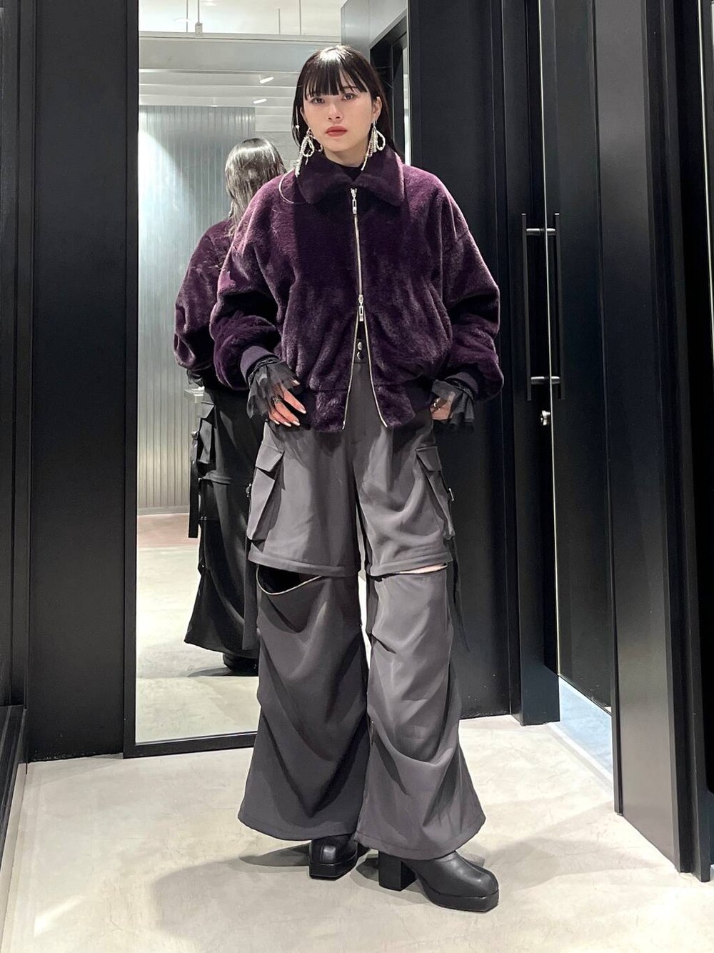 グレー系のカーゴパンツ、ブラック系のブーツ、ブラック系のTシャツ/カットソーを着用したレディースの冬コーディネートの1枚目の写真