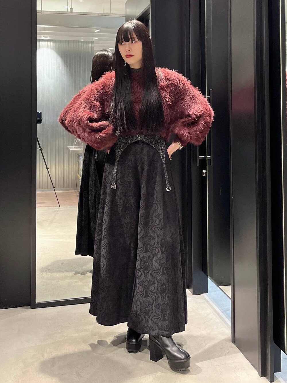 レッド系のニット/セーター、ブラック系のブーツ、ブラック系のニット/セーターを着用したレディースの秋コーディネートの1枚目の写真