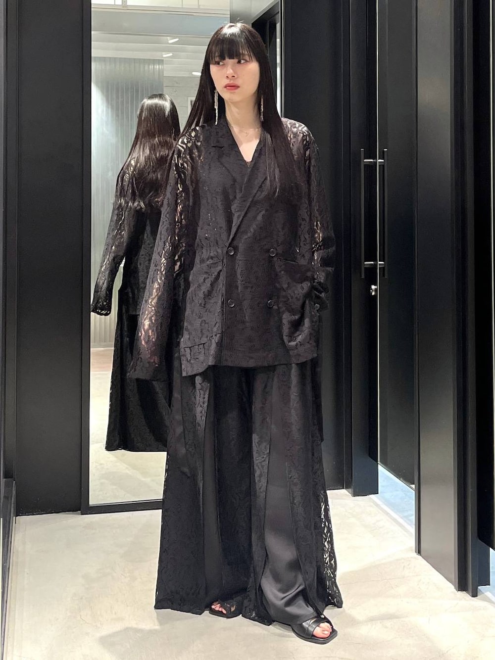 ブラック系のテーラードジャケット、ブラック系のサンダル、ブラック系のその他パンツを着用したレディースの春コーディネートの1枚目の写真