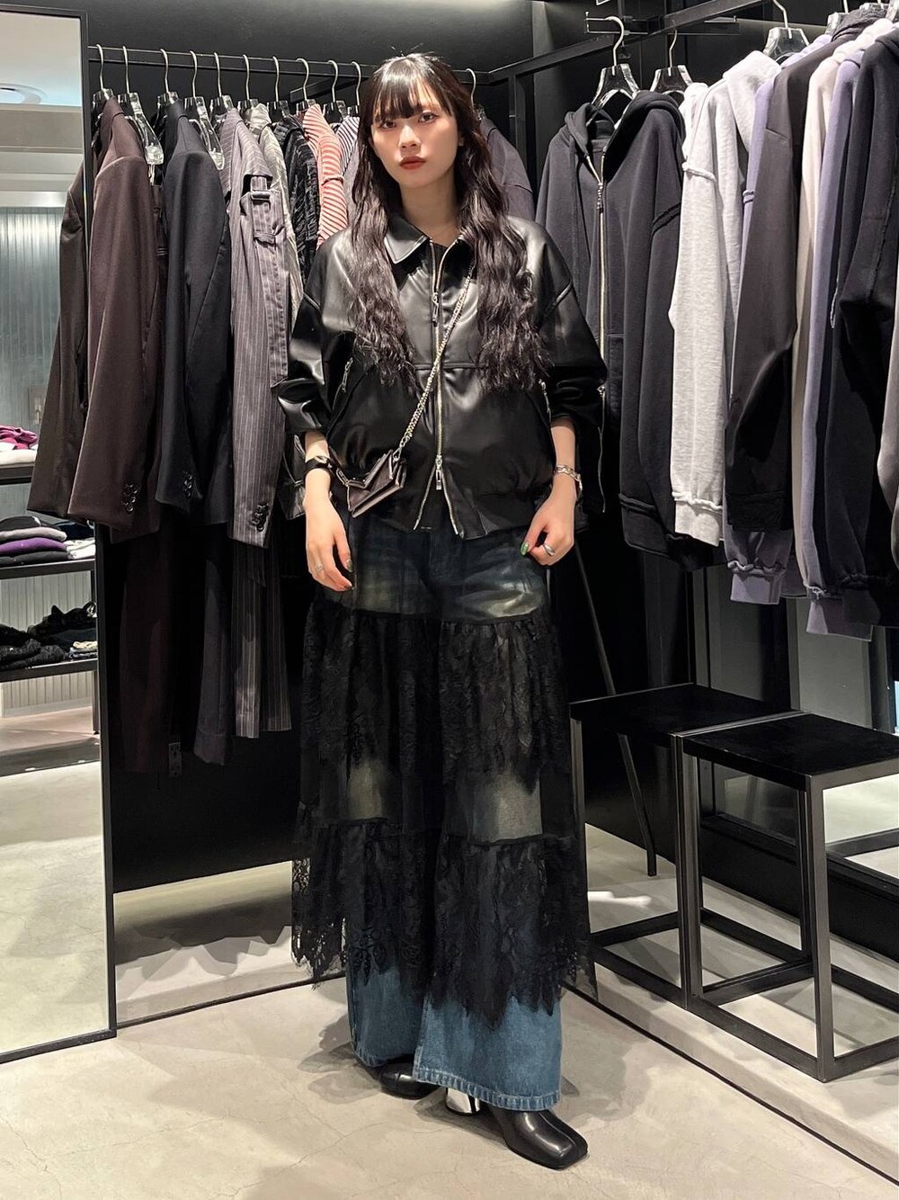 ブルー系のデニムパンツ、ブラック系のブーツ、ブラック系のブルゾンを着用したレディースの秋コーディネートの1枚目の写真