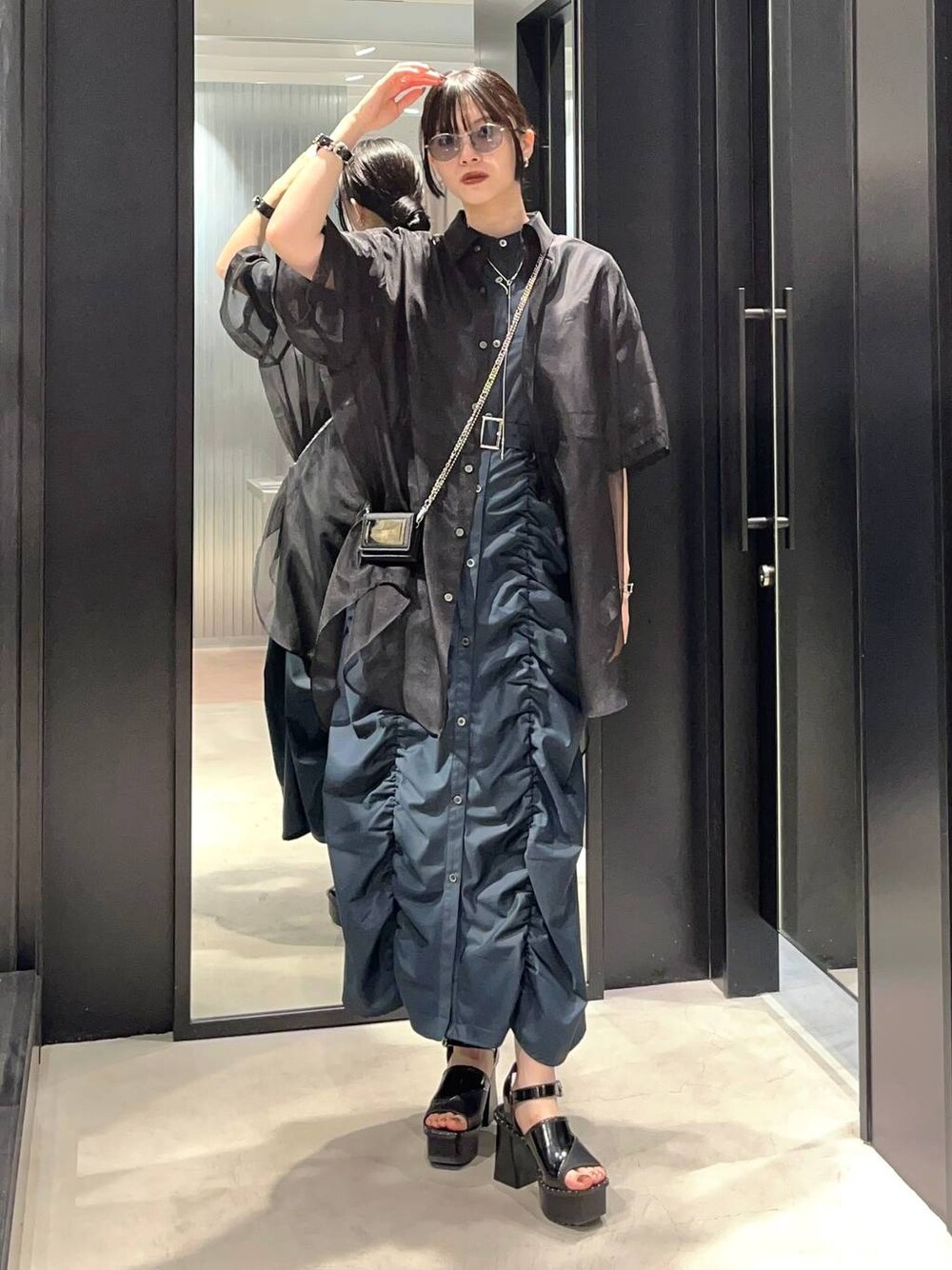 ブラック系のサンダル、ブラック系のシャツ/ブラウス、グリーン系のワンピースを着用したレディースの春コーディネートの1枚目の写真