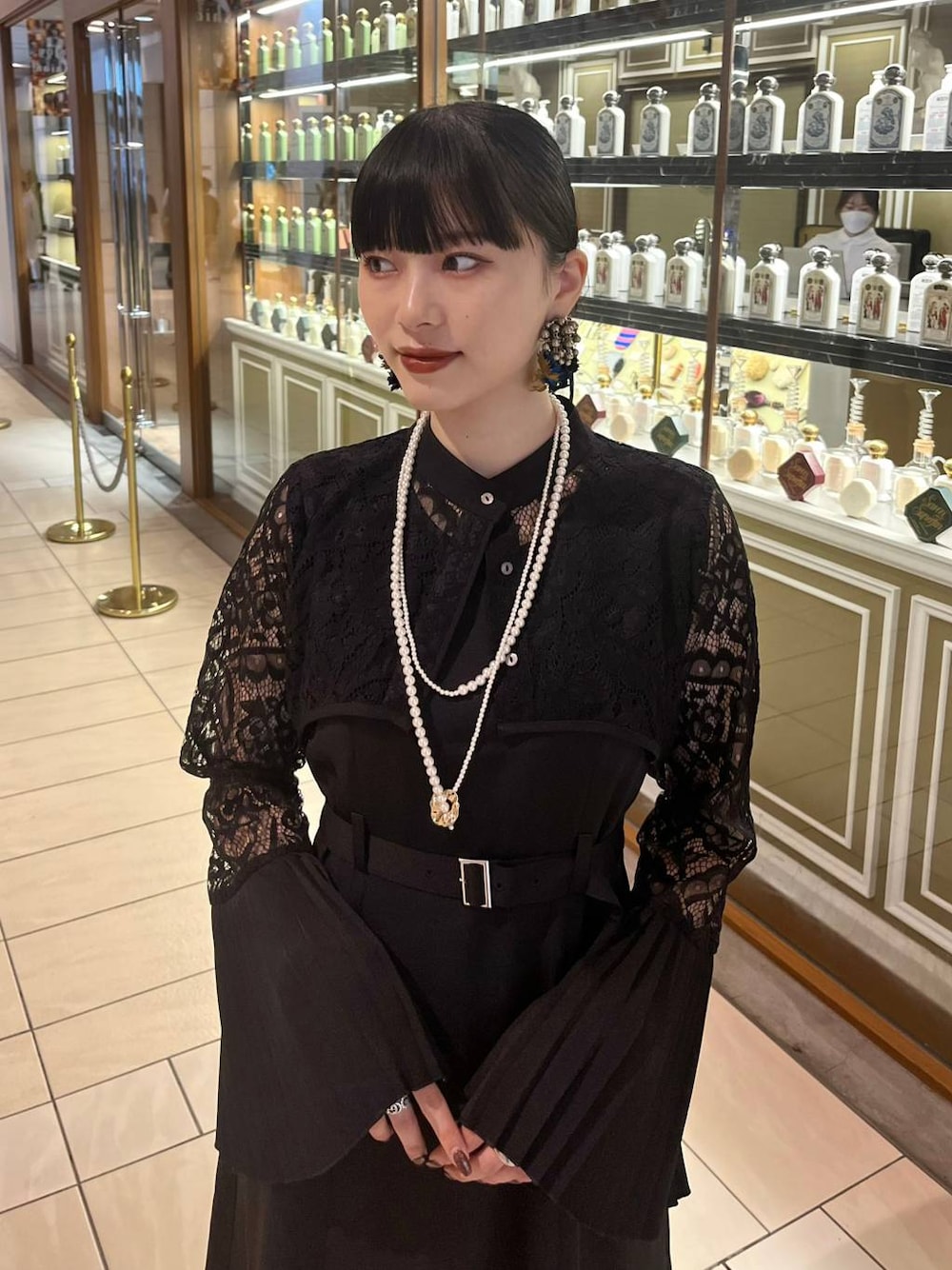 ブラック系のドレス、ゴールド系のネックレスを着用したレディースの夏コーディネートの1枚目の写真