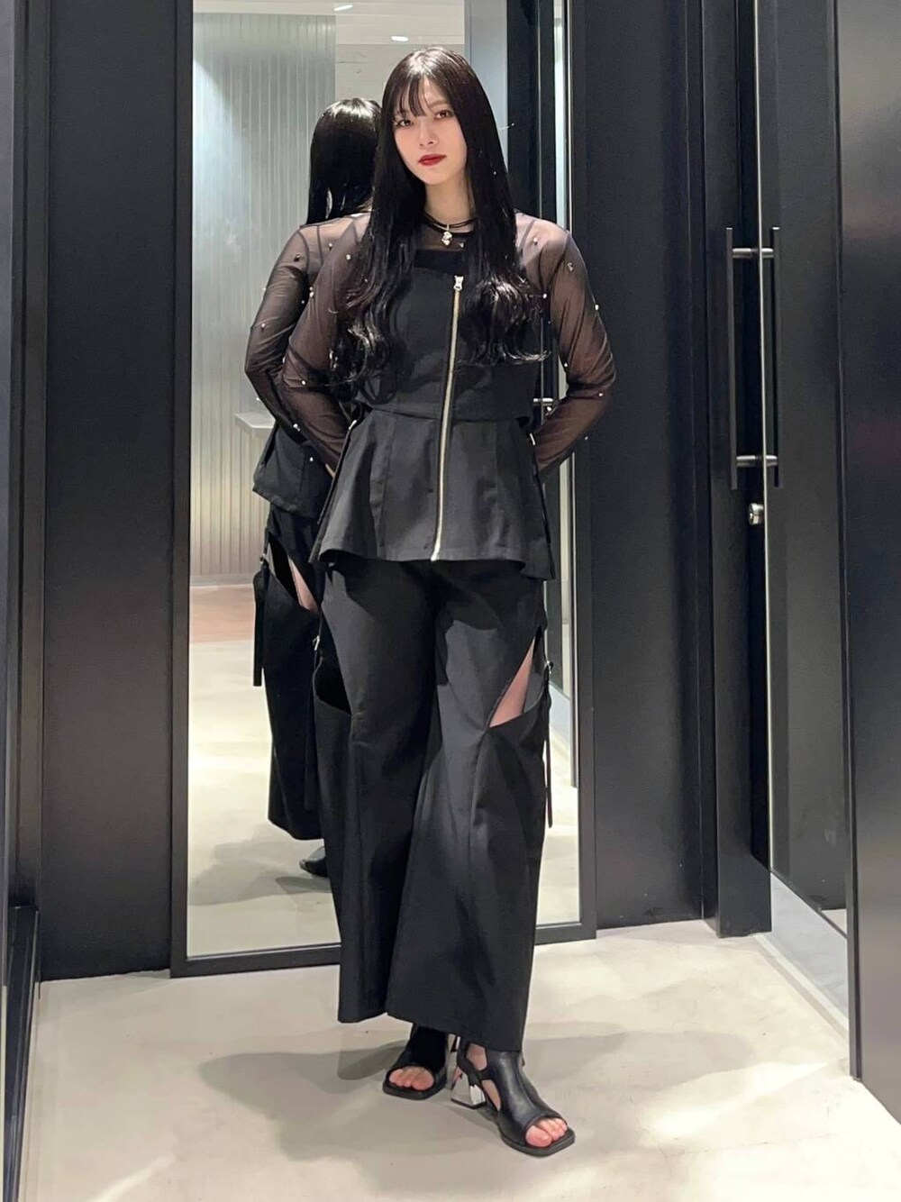 ブラック系のTシャツ/カットソー、ブラック系のサンダル、ブラック系のベストを着用したレディースの春コーディネートの1枚目の写真