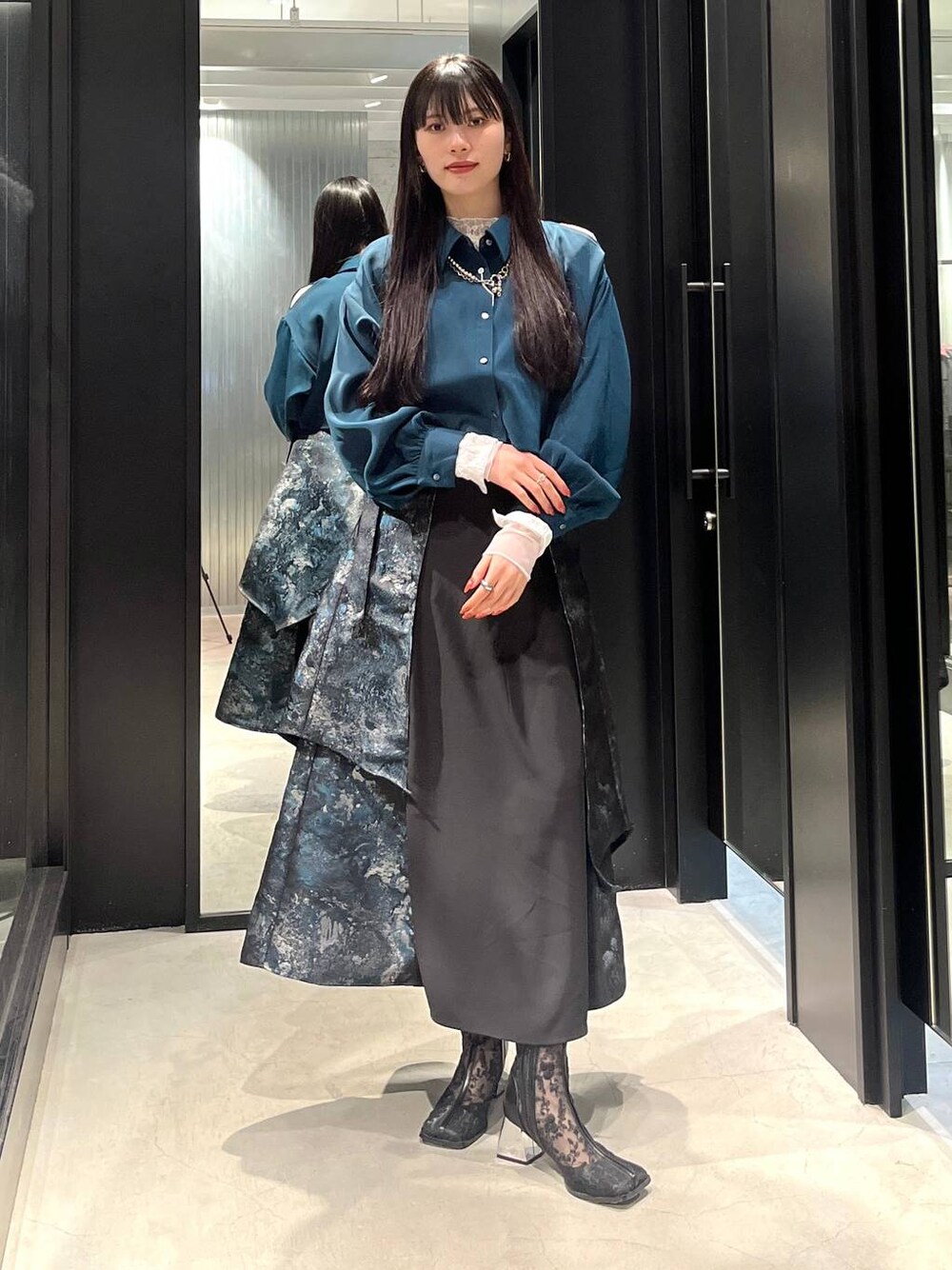 ブラック系のブーツ、グリーン系のシャツ/ブラウス、グリーン系のスカートを着用したレディースの春コーディネートの1枚目の写真