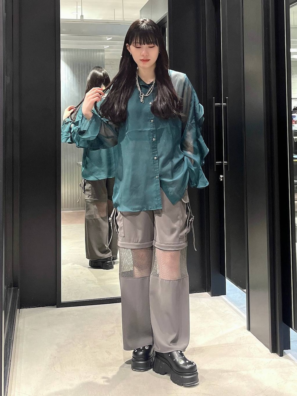 グリーン系のシャツ/ブラウス、ブラック系のサンダル、グレー系のカーゴパンツを着用したレディースの春コーディネートの1枚目の写真