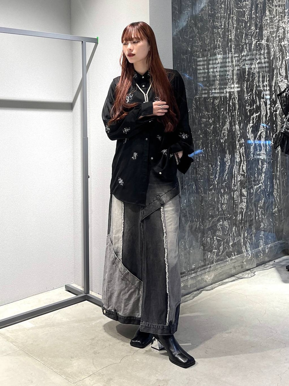 ブラック系のデニムスカート、ブラック系のシャツ/ブラウス、ブラック系のブーツを着用したレディースの秋コーディネートの1枚目の写真