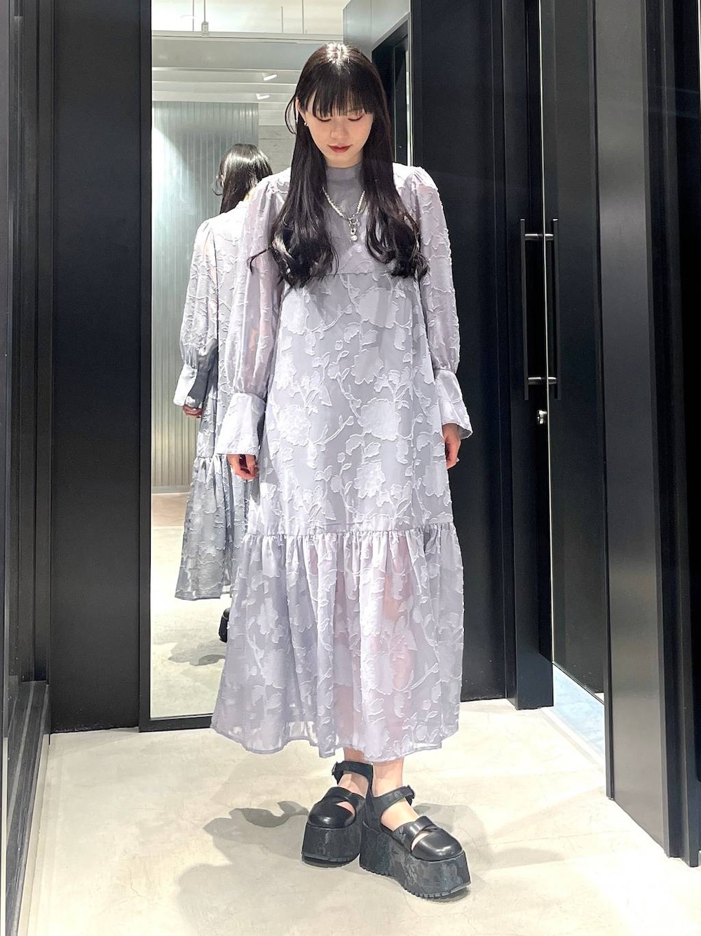 ブラック系のサンダル、グレー系のワンピース、ホワイト系のネックレスを着用したレディースの春コーディネートの1枚目の写真