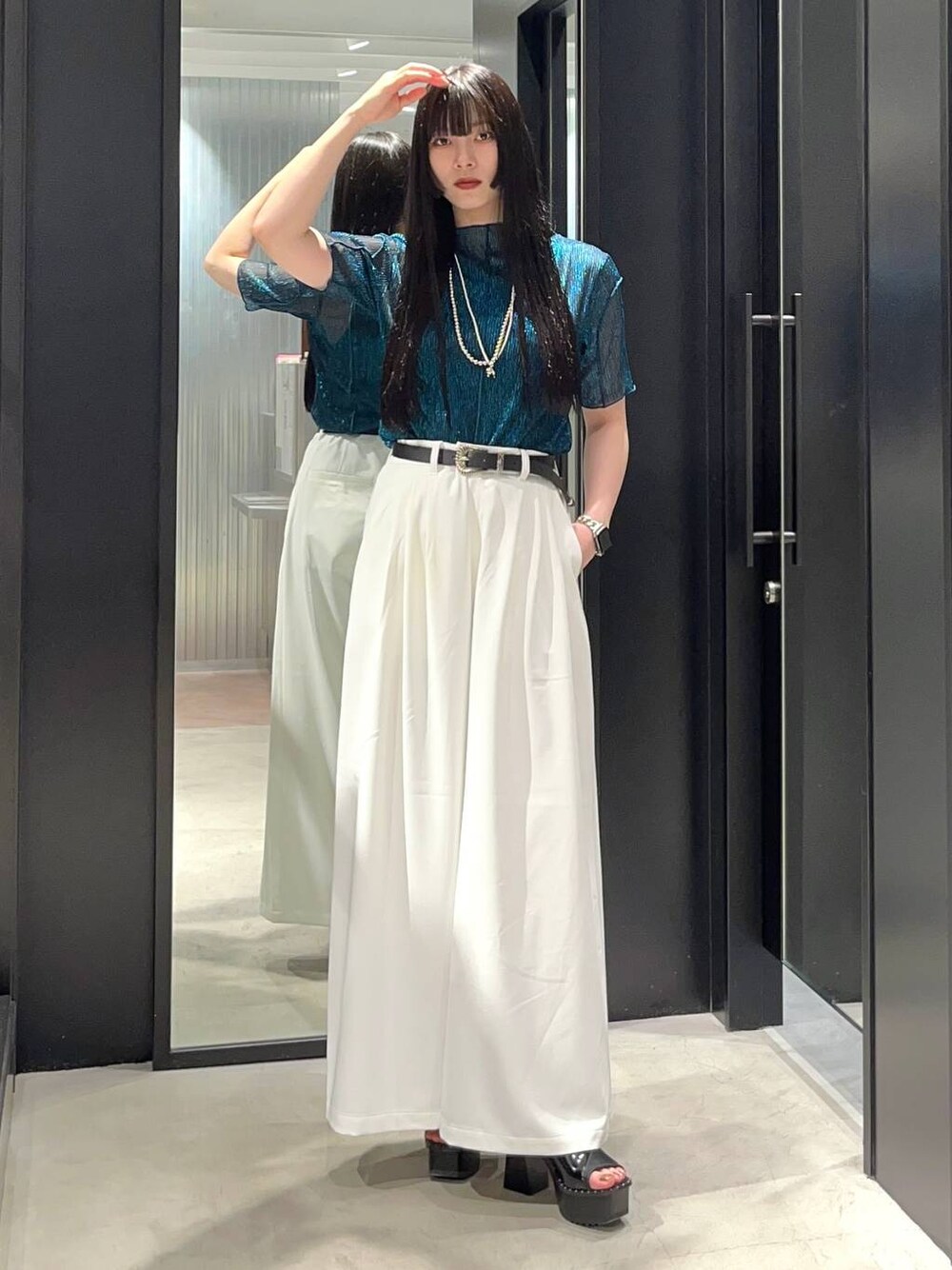 ブラック系のサンダル、ブルー系のTシャツ/カットソー、ホワイト系のスラックスを着用したレディースの春コーディネートの1枚目の写真