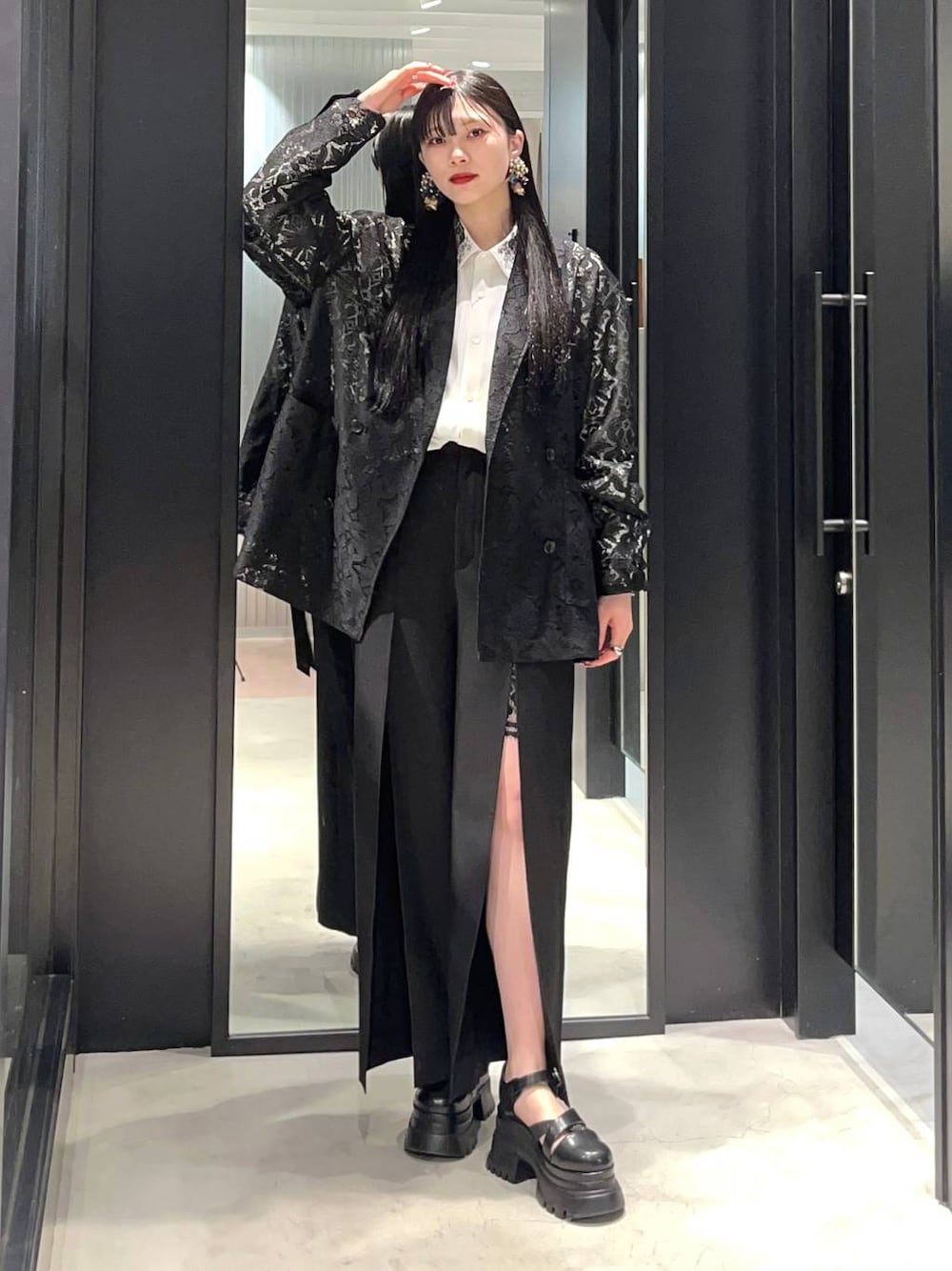 ホワイト系のシャツ/ブラウス、ブラック系のテーラードジャケット、ブラック系のサンダルを着用したレディースの春コーディネートの1枚目の写真