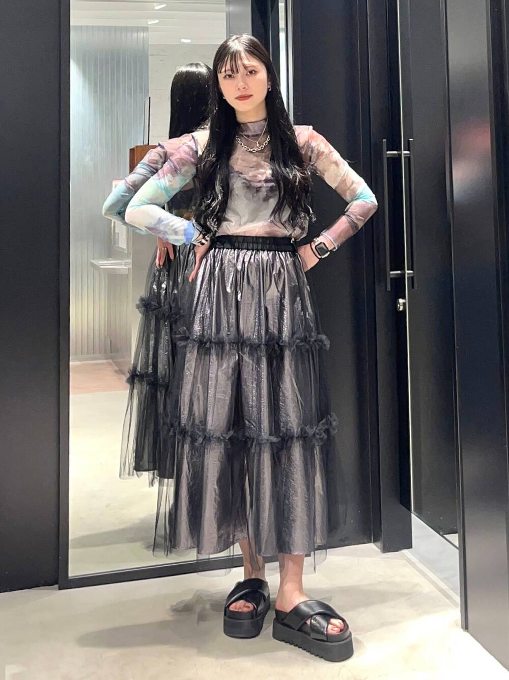 ブラック系のサンダル、シルバー系のスカート、その他のTシャツ/カットソーを着用したレディースの春コーディネートの1枚目の写真