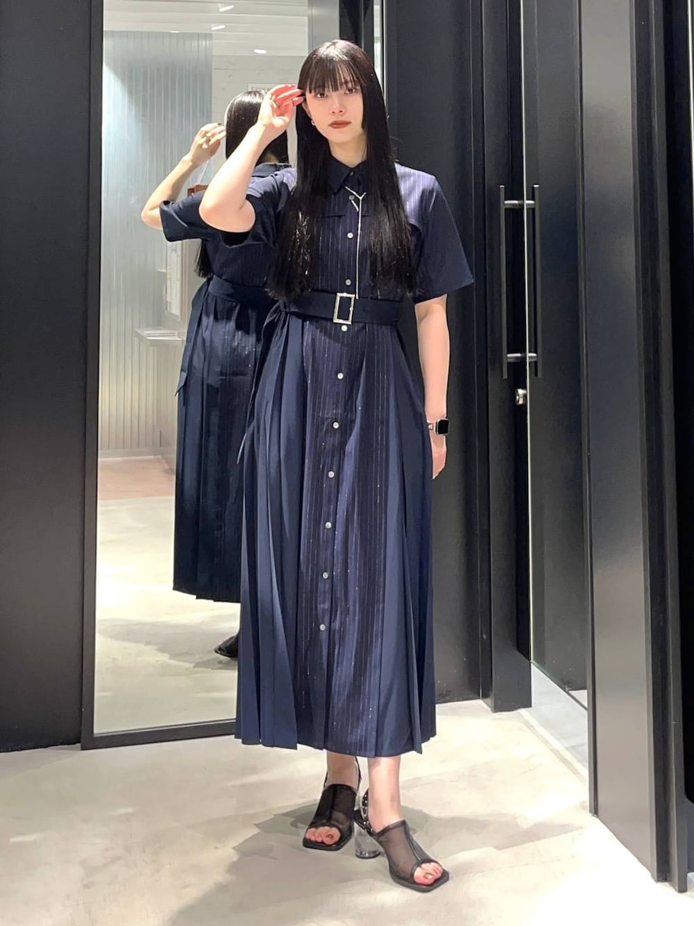 ブラック系のサンダル、ブルー系のワンピース、シルバー系のネックレスを着用したレディースの春コーディネートの1枚目の写真