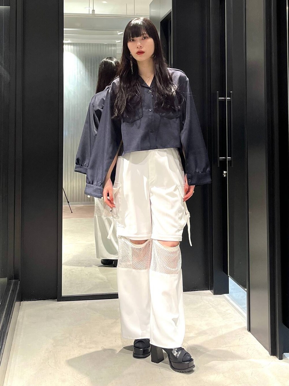 ブラック系のブーツ、ブルー系のシャツ/ブラウス、ホワイト系のカーゴパンツを着用したレディースの春コーディネートの1枚目の写真