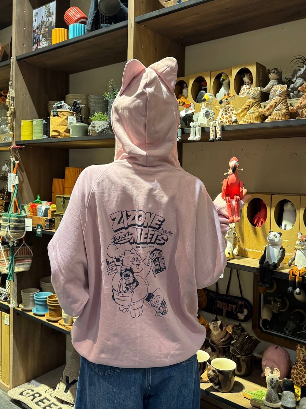ブルー系のデニムパンツ、ブラック系のスニーカー、ピンク系のパーカーを着用したレディースの冬コーディネートの1枚目の写真