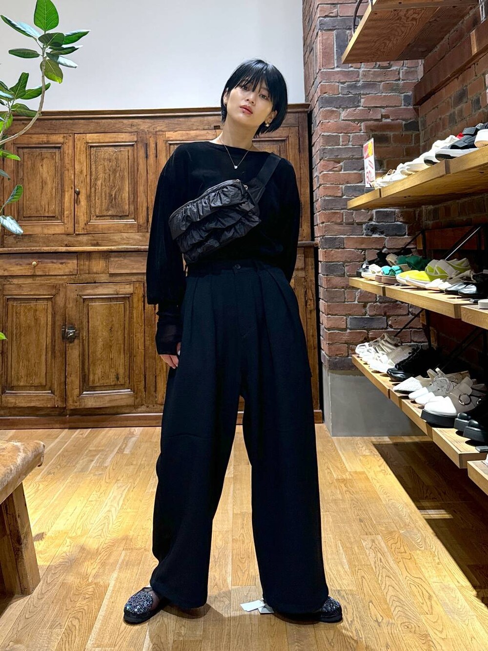 ブラック系のその他パンツ、ブラック系のTシャツ/カットソー、ブラック系のボディバッグ/ウエストポーチを着用したレディースの秋コーディネートの1枚目の写真