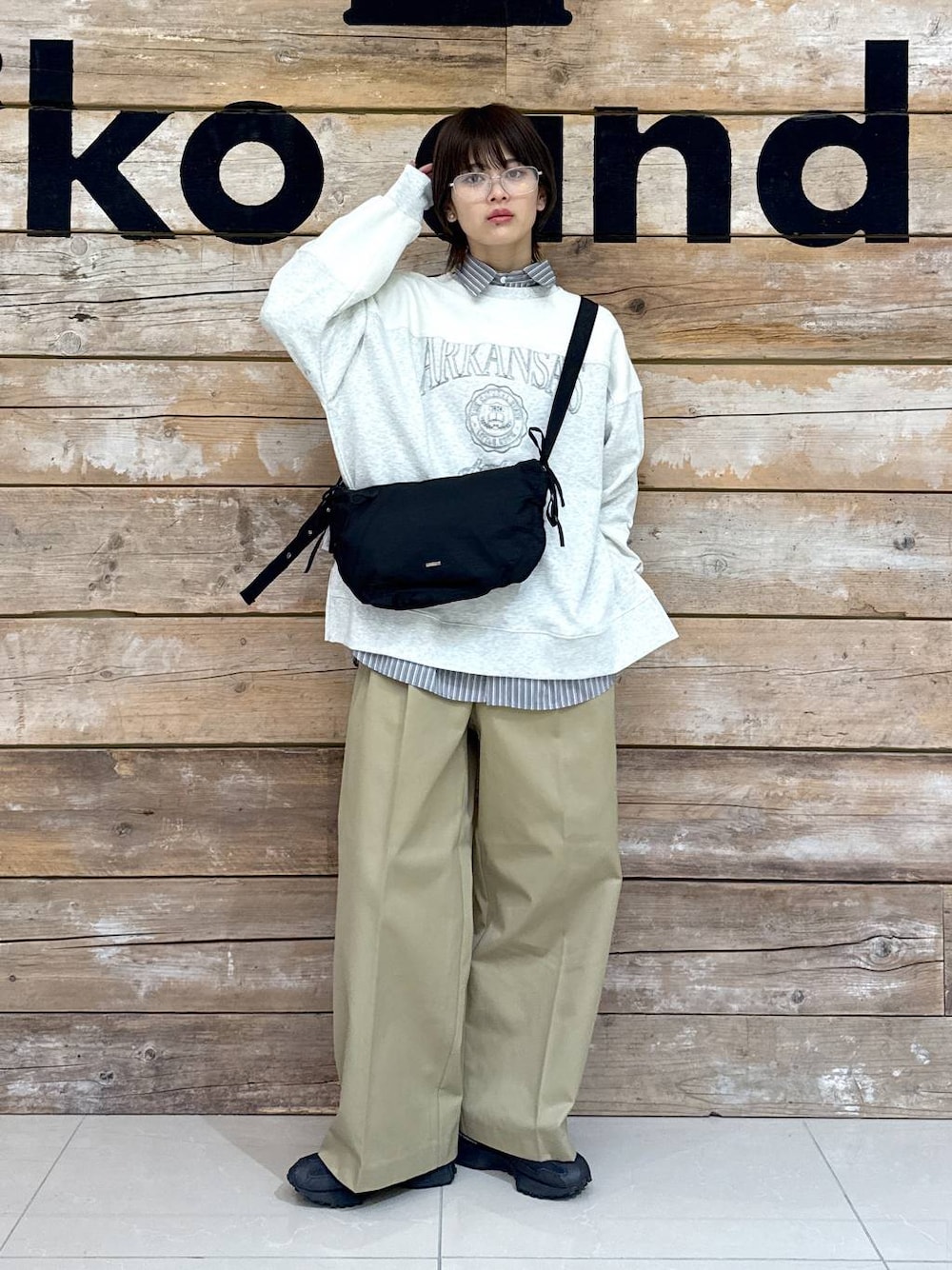 ベージュ系のチノパンツ、グレー系のシャツ/ブラウス、ブラック系のスニーカーを着用したレディースの冬コーディネートの1枚目の写真