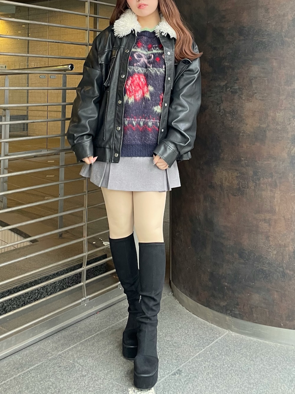 ブラック系のブルゾン、ブルー系のニット/セーター、グレー系のスカートを着用したレディースの秋コーディネートの1枚目の写真