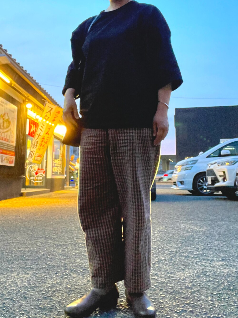 ブラウン系のパンツ、ブラウン系のローファー、ブラック系のTシャツ/カットソーを着用したレディースの夏コーディネートの1枚目の写真