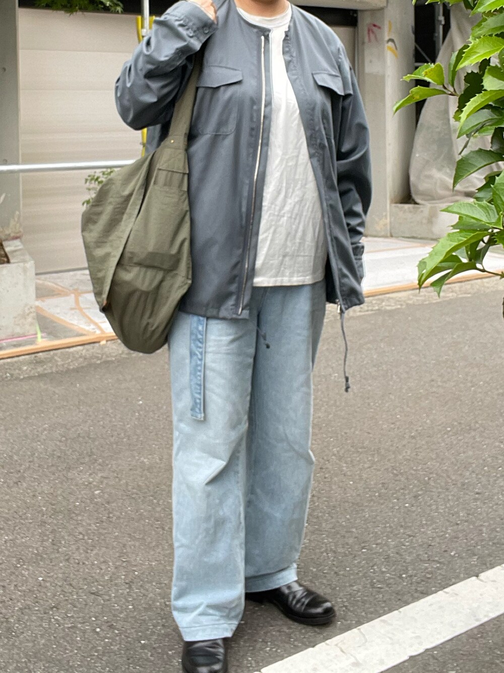 ブルー系のデニムパンツ、シルバー系のシャツ/ブラウス、グリーン系のショルダーバッグを着用したレディースの夏コーディネートの1枚目の写真