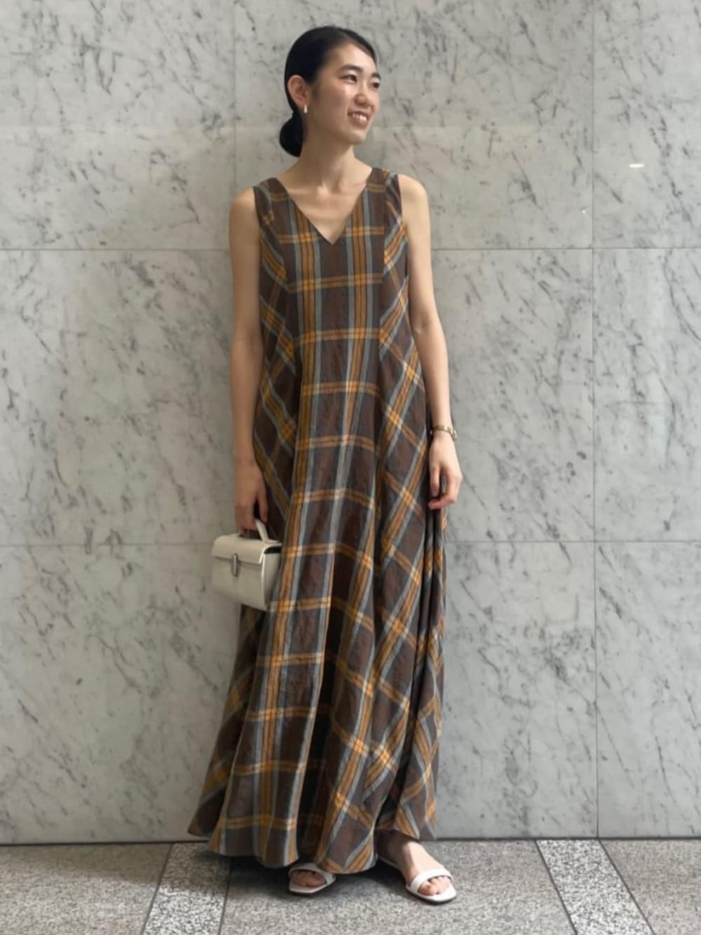 オレンジ系のワンピースを着用したレディースの夏コーディネートの1枚目の写真