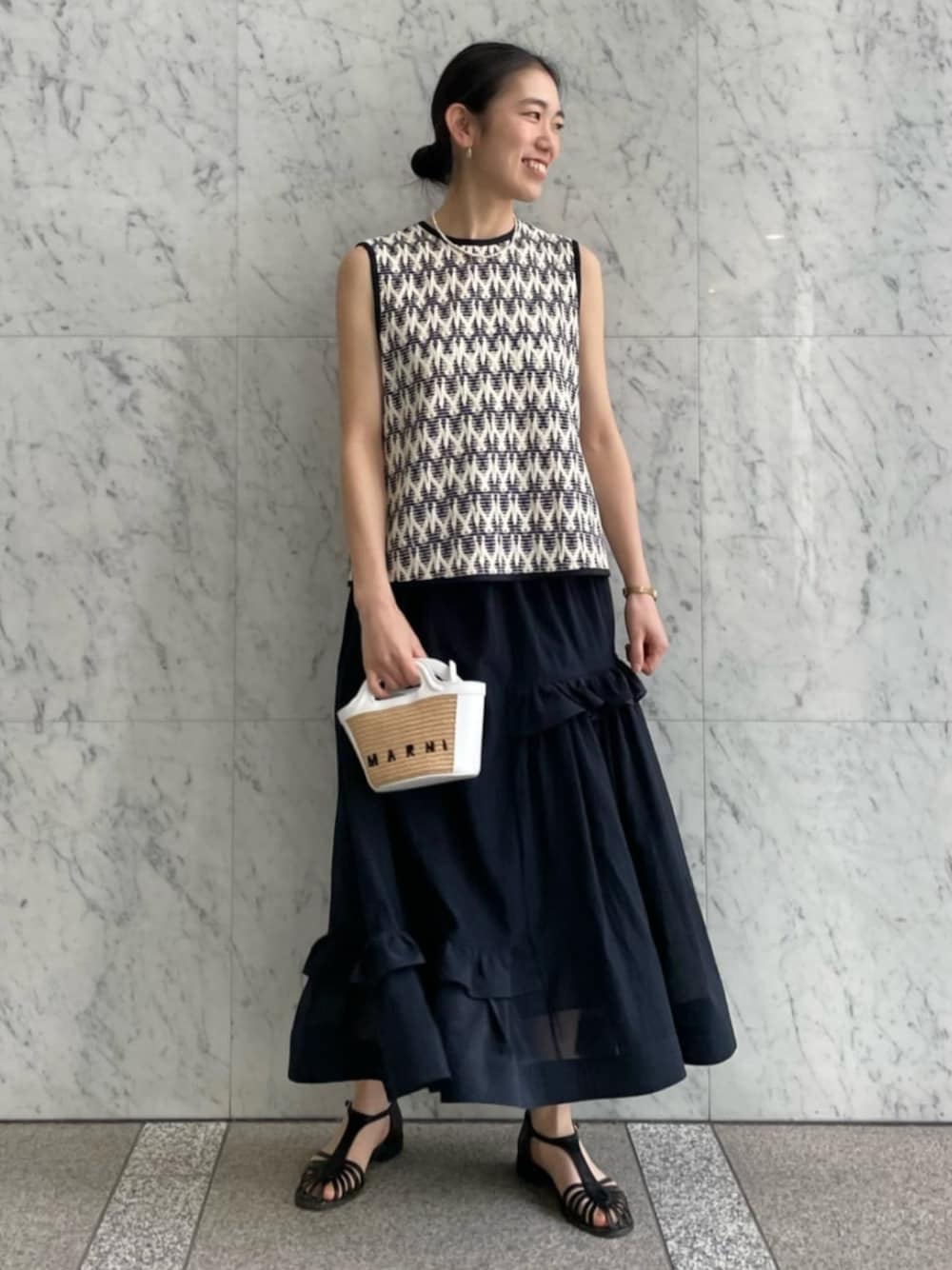 ホワイト系のニット/セーター、ホワイト系のシャツ/ブラウス、ブルー系のスカートを着用したレディースの春コーディネートの1枚目の写真