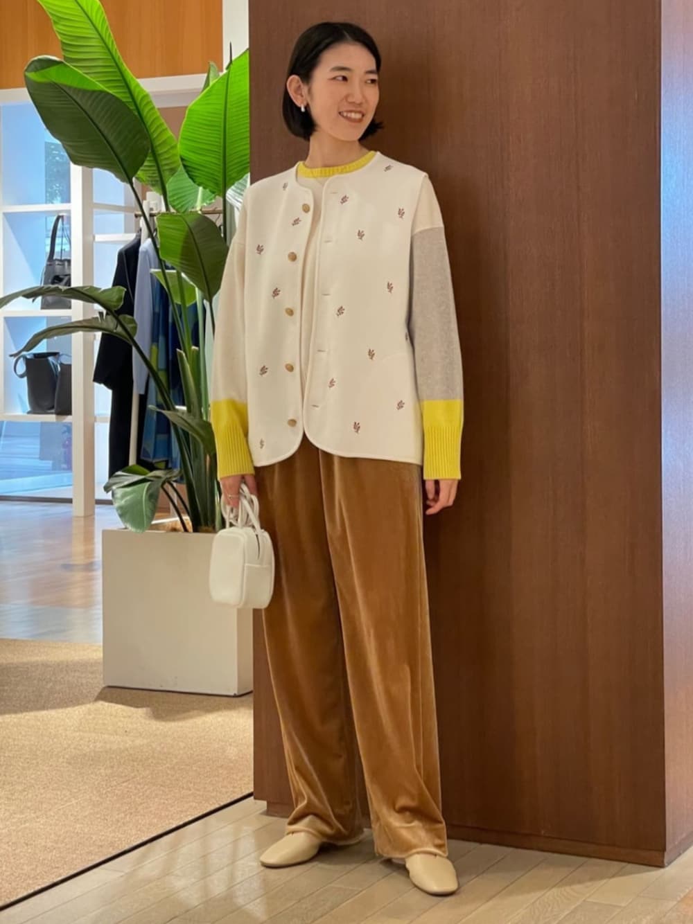 ベージュ系のパンプス、ホワイト系のベスト、ホワイト系のニット/セーターを着用したレディースの秋コーディネートの1枚目の写真