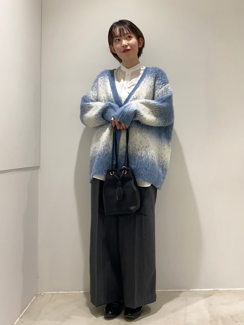 ホワイト系のシャツ/ブラウス、ブラック系のショルダーバッグ、ブルー系のカーディガン/ボレロを着用したレディースの秋コーディネートの1枚目の写真