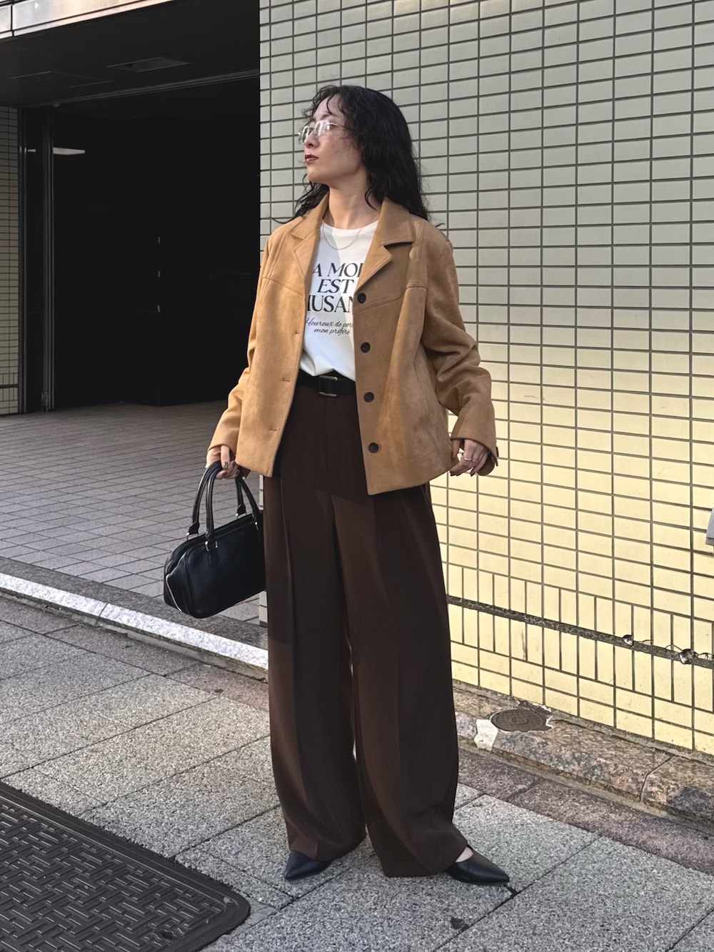 ベージュ系のダウンジャケット/コート、ホワイト系のTシャツ/カットソー、ブラウン系のスラックスを着用したレディースの秋コーディネートの1枚目の写真