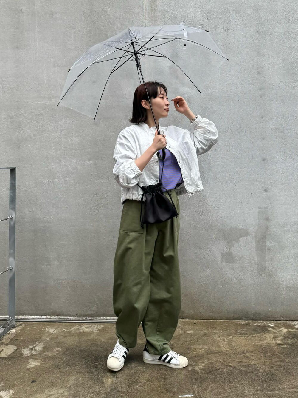 ホワイト系のブルゾン、パープル系のTシャツ/カットソー、グリーン系のその他パンツを着用したレディースの春コーディネートの1枚目の写真