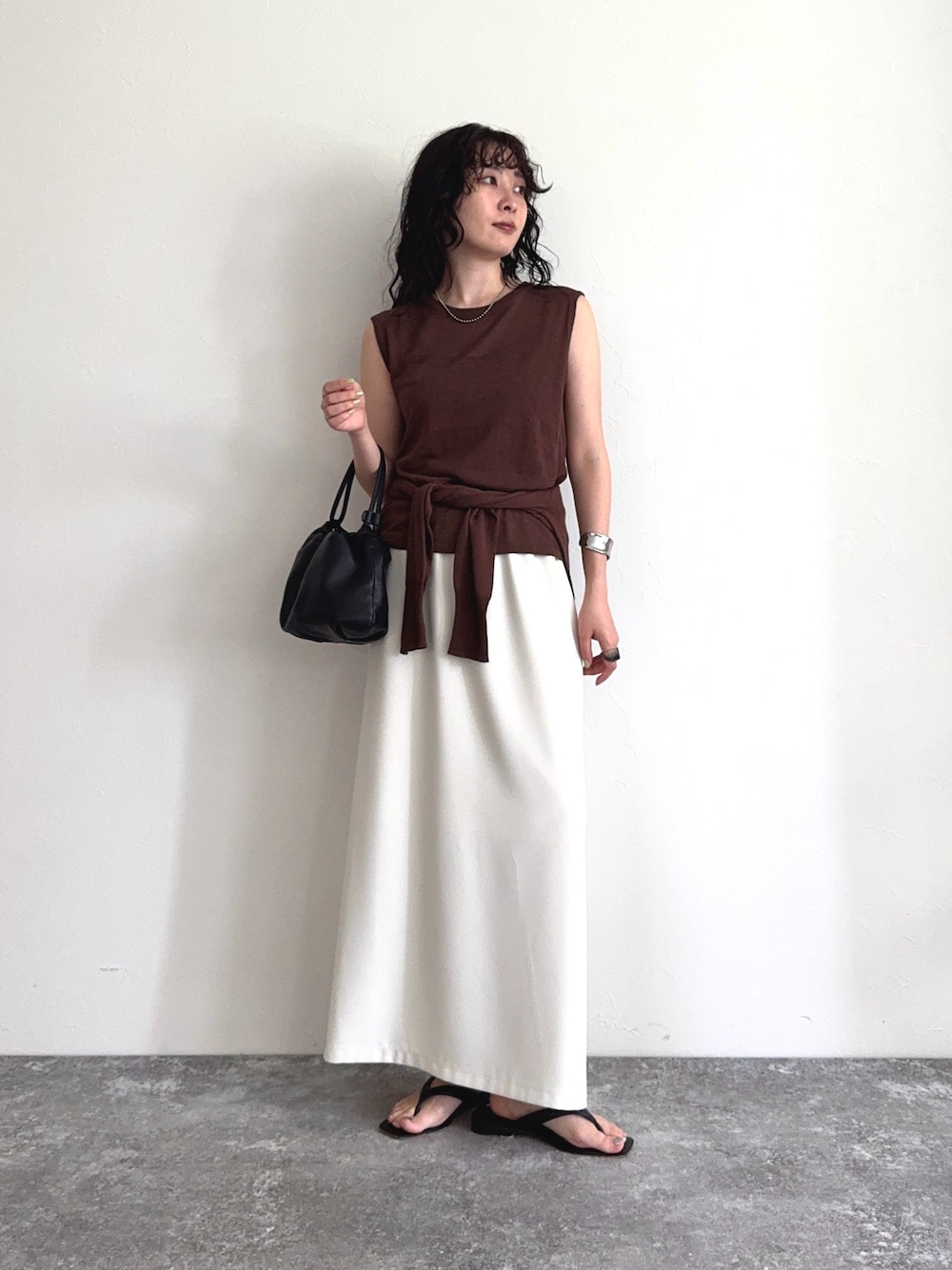 ブラウン系のタンクトップ、ブラウン系のカーディガン/ボレロ、ホワイト系のスカートを着用したレディースの夏コーディネートの1枚目の写真