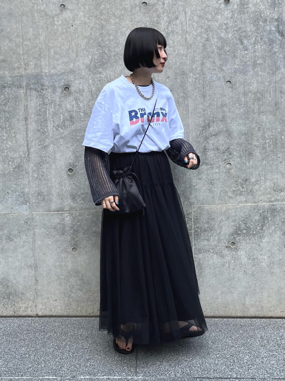 ホワイト系のTシャツ/カットソー、ブラック系のスカート、グレー系のニット/セーターを着用したレディースの夏コーディネートの1枚目の写真