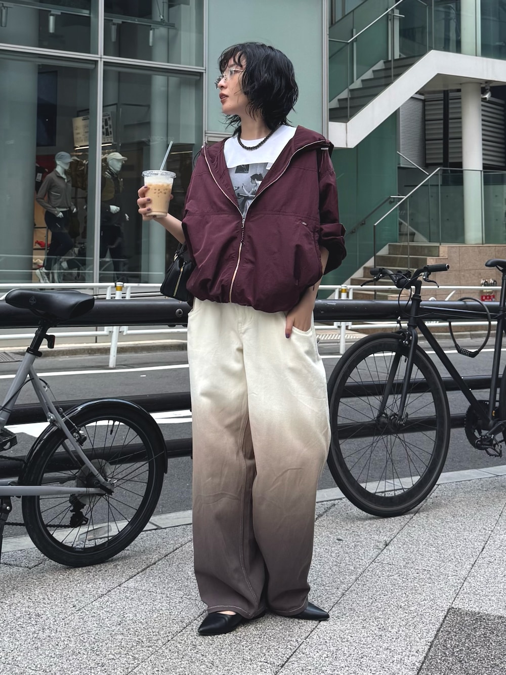 レッド系のブルゾン、ホワイト系のTシャツ/カットソー、ブラウン系のデニムパンツを着用したレディースの秋コーディネートの1枚目の写真