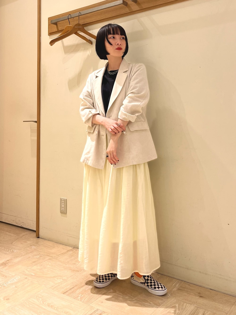 ベージュ系のテーラードジャケット、ブラック系のTシャツ/カットソー、ベージュ系のスカートを着用したレディースの春コーディネートの1枚目の写真