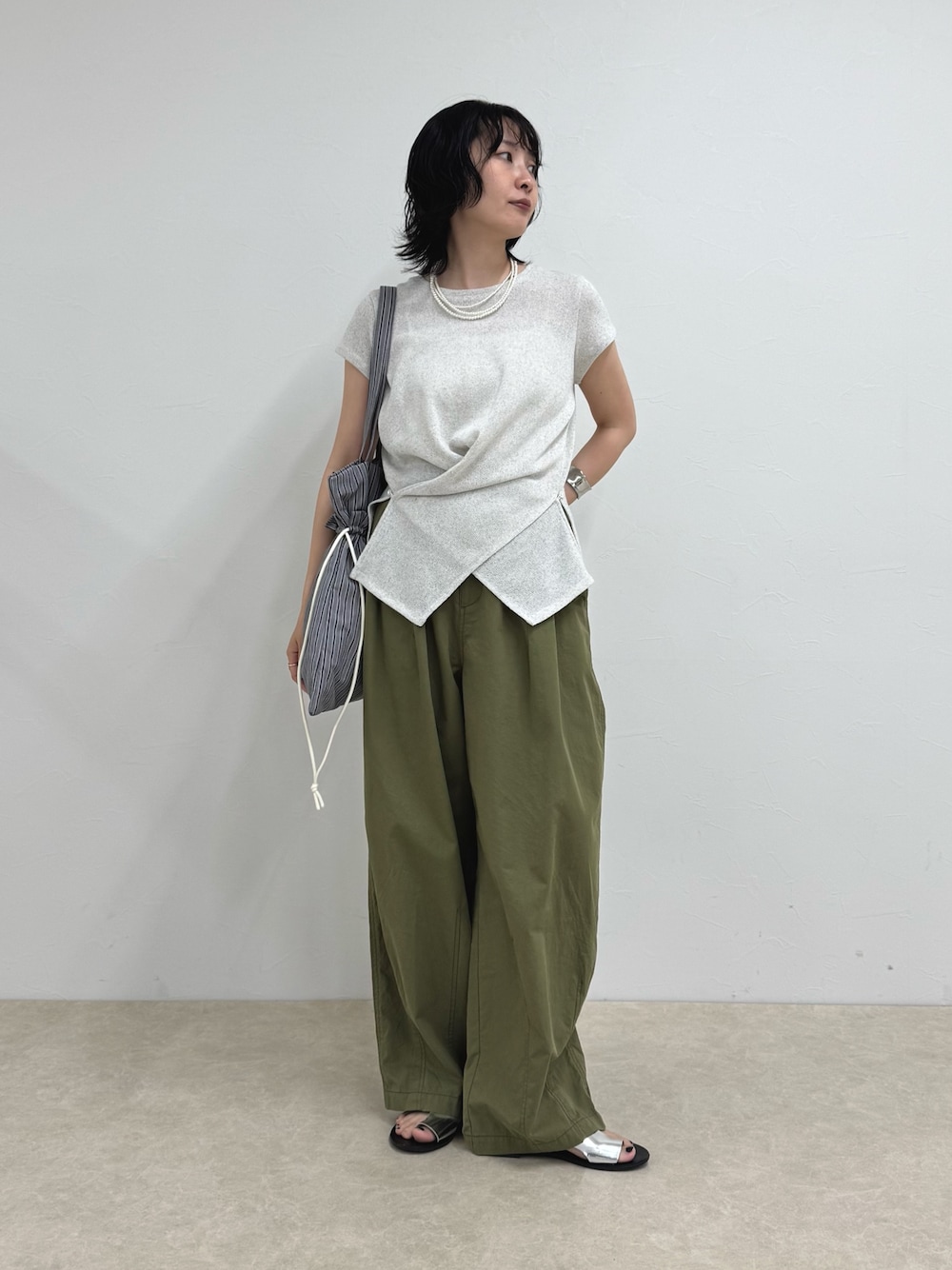 ホワイト系のTシャツ/カットソー、ブラック系のトートバッグ、グリーン系のその他パンツを着用したレディースの夏コーディネートの1枚目の写真