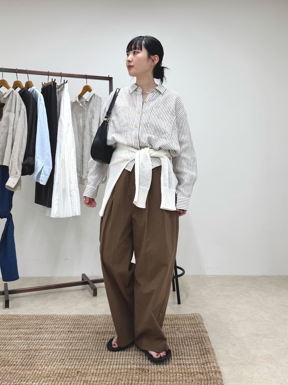 ベージュ系のシャツ/ブラウス、ブラウン系のその他パンツ、ホワイト系のニット/セーターを着用したレディースの春コーディネートの1枚目の写真