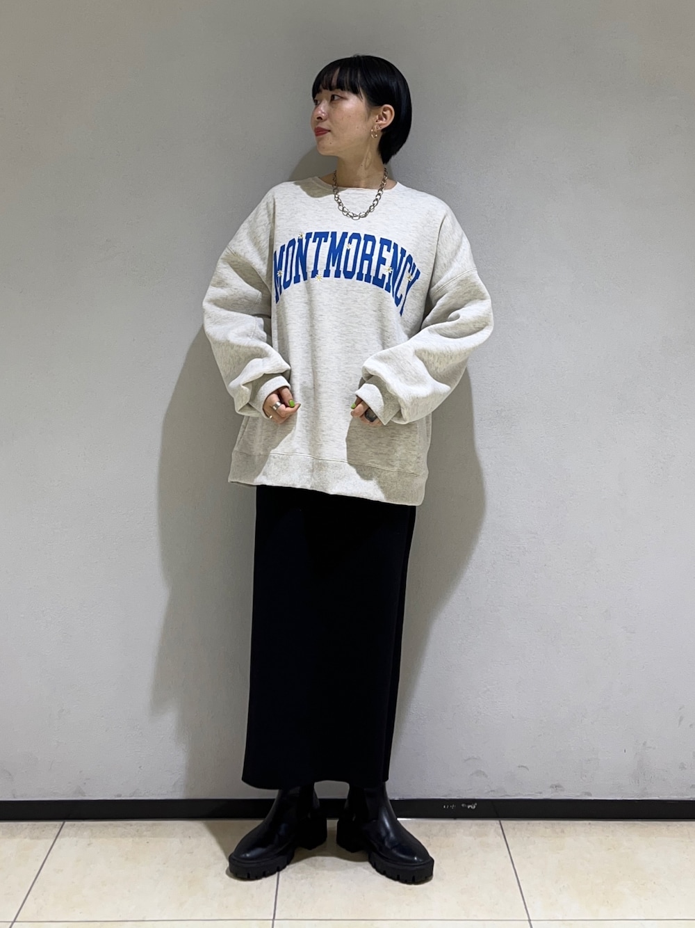 グレー系のスウェット、ブラック系のスカートを着用したレディースの冬コーディネートの1枚目の写真