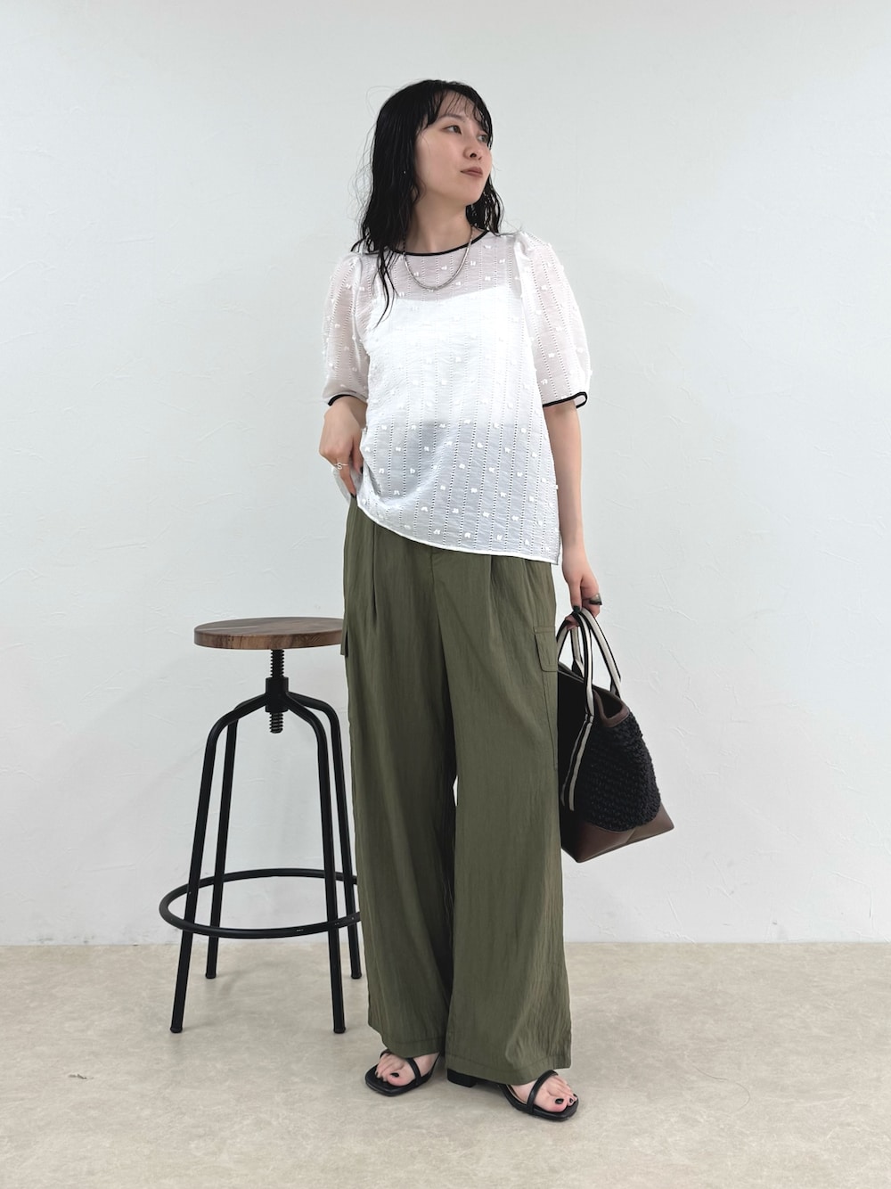 ホワイト系のシャツ/ブラウス、グリーン系のその他パンツ、ブラック系のトートバッグを着用したレディースの春コーディネートの1枚目の写真
