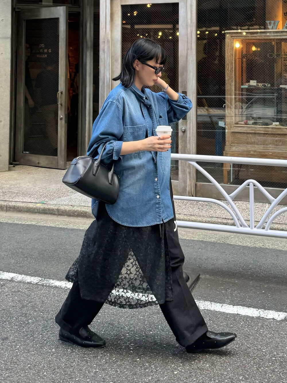ブルー系のシャツ/ブラウス、ブルー系のチノパンツ、ブラック系のスカートを着用したレディースの秋コーディネートの1枚目の写真