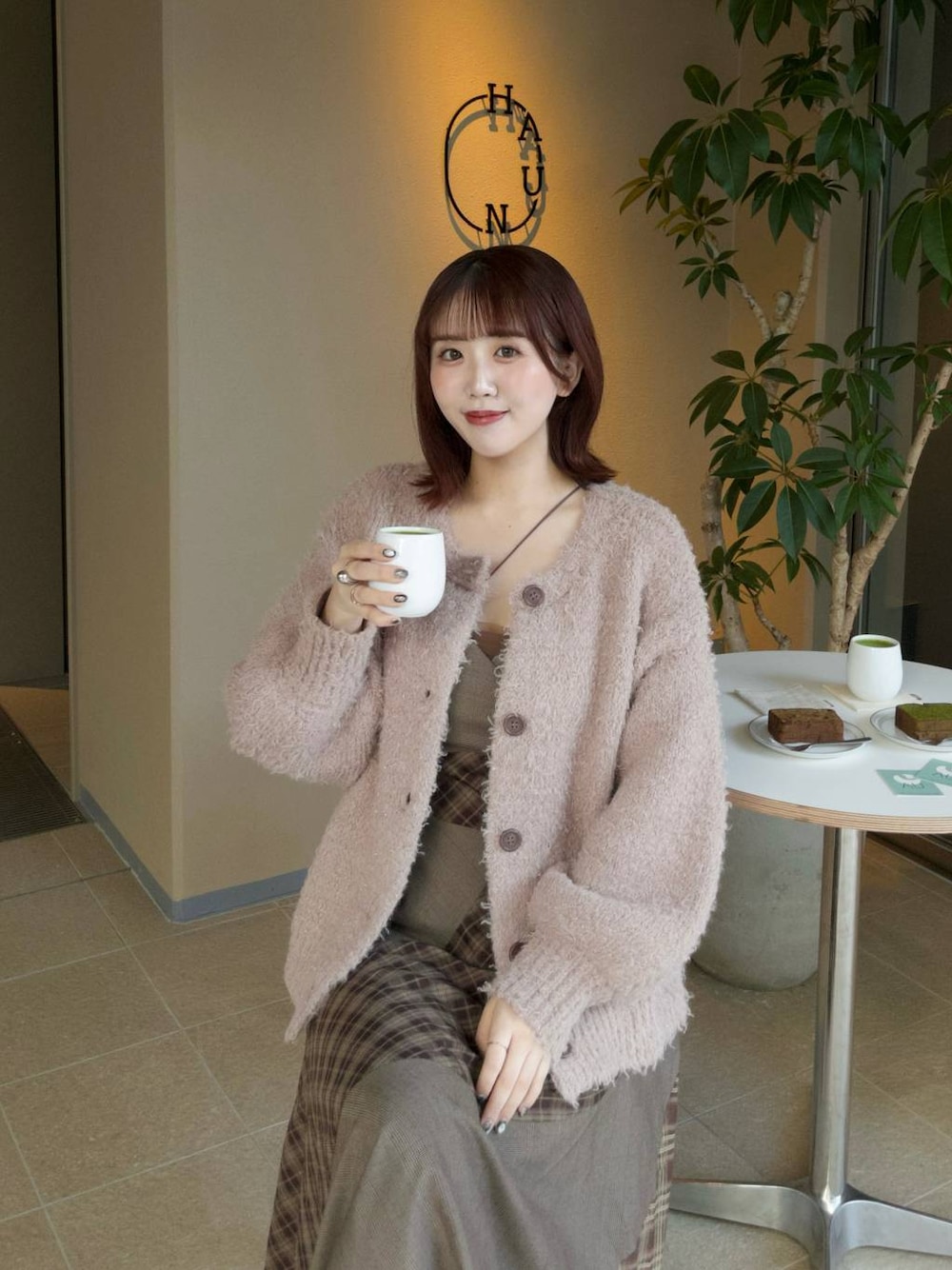 ホワイト系のショルダーバッグ、ベージュ系のカーディガン/ボレロ、ブラウン系のワンピースを着用したレディースの秋コーディネートの1枚目の写真