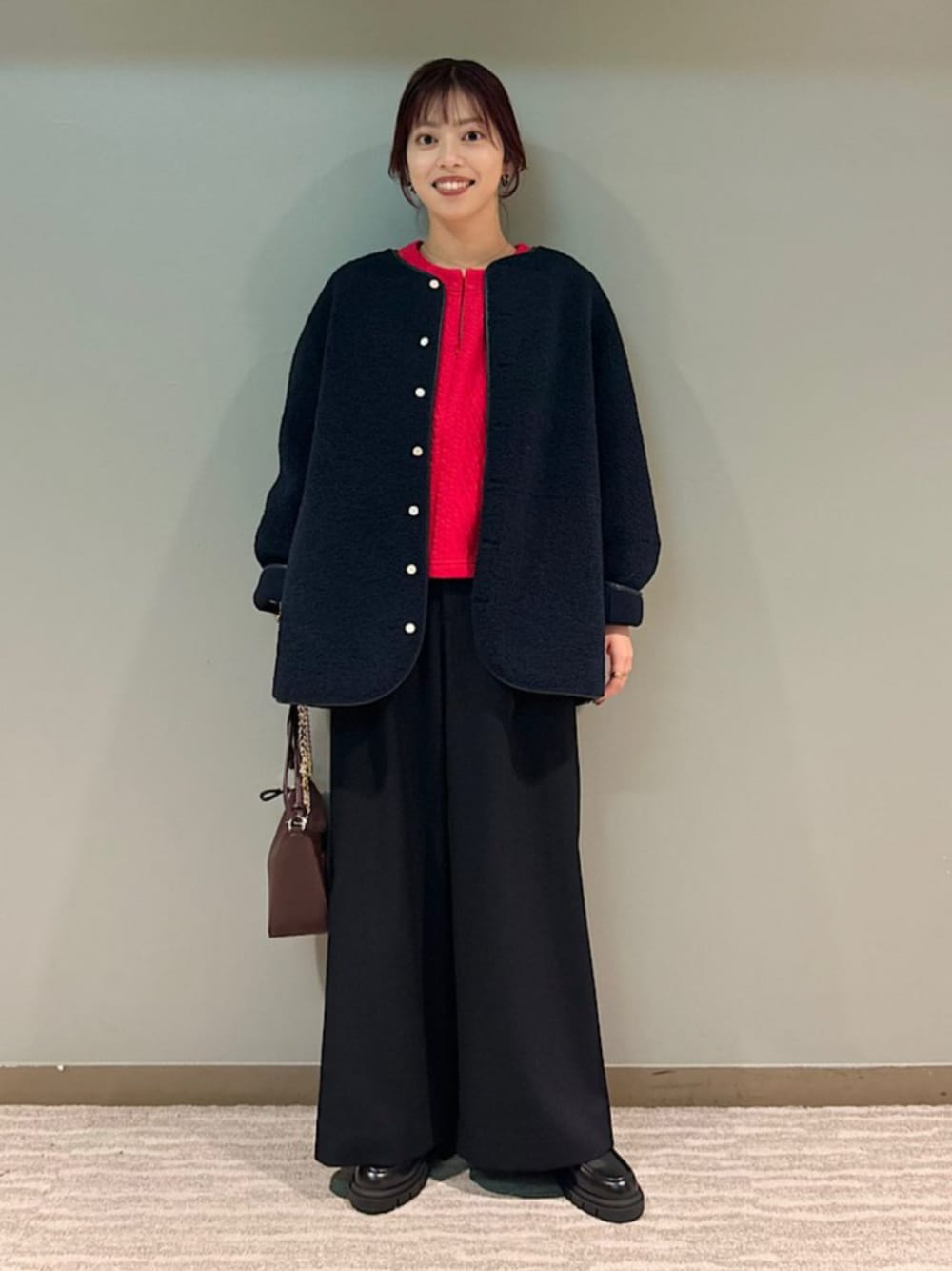 ブラック系のローファー、レッド系のショルダーバッグ、レッド系のスウェットを着用したレディースの秋コーディネートの1枚目の写真