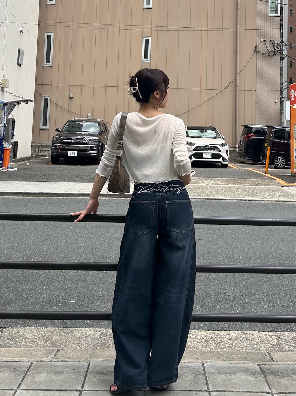 ブルー系のデニムパンツ、ホワイト系のキャミソールを着用したレディースの夏コーディネートの1枚目の写真