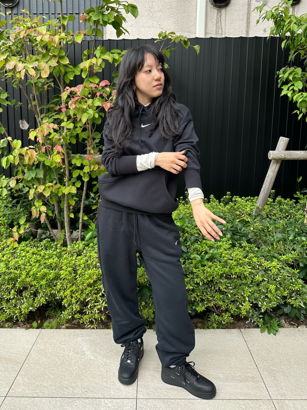 ブラック系のスニーカー、ブラック系のパーカー、ブラック系のスウェットパンツを着用したレディースの秋コーディネートの1枚目の写真