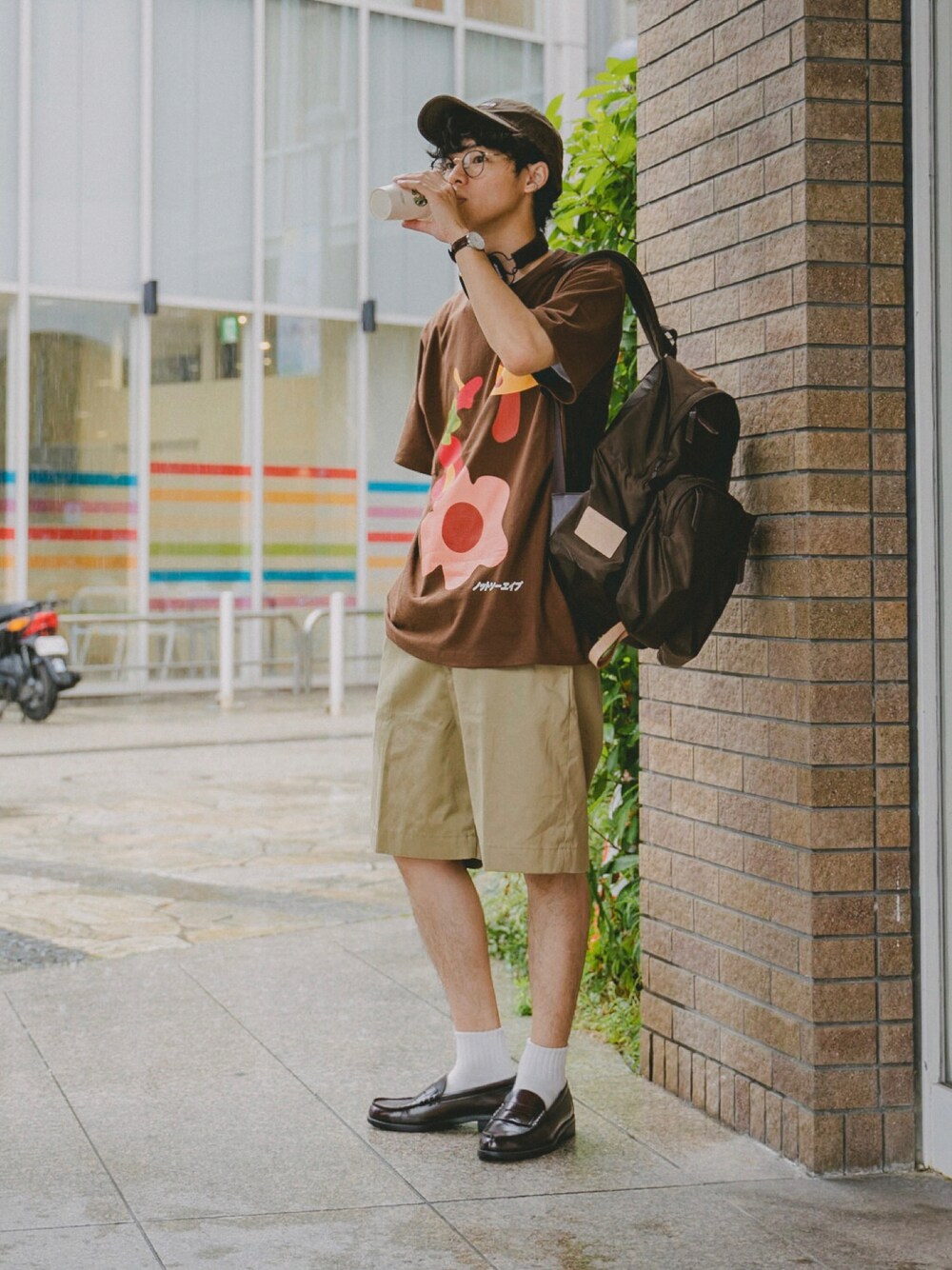ブラウン系のTシャツ/カットソー、ベージュ系のパンツ、ブラウン系のローファーを着用したメンズの夏コーディネートの1枚目の写真