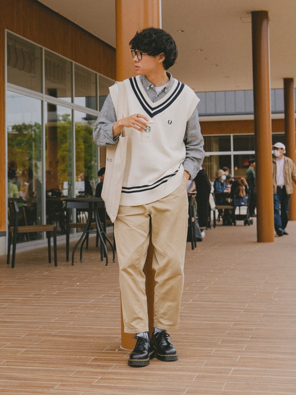 ホワイト系のベスト、ブラック系のシャツ/ブラウス、ベージュ系のチノパンツを着用したメンズの春コーディネートの1枚目の写真