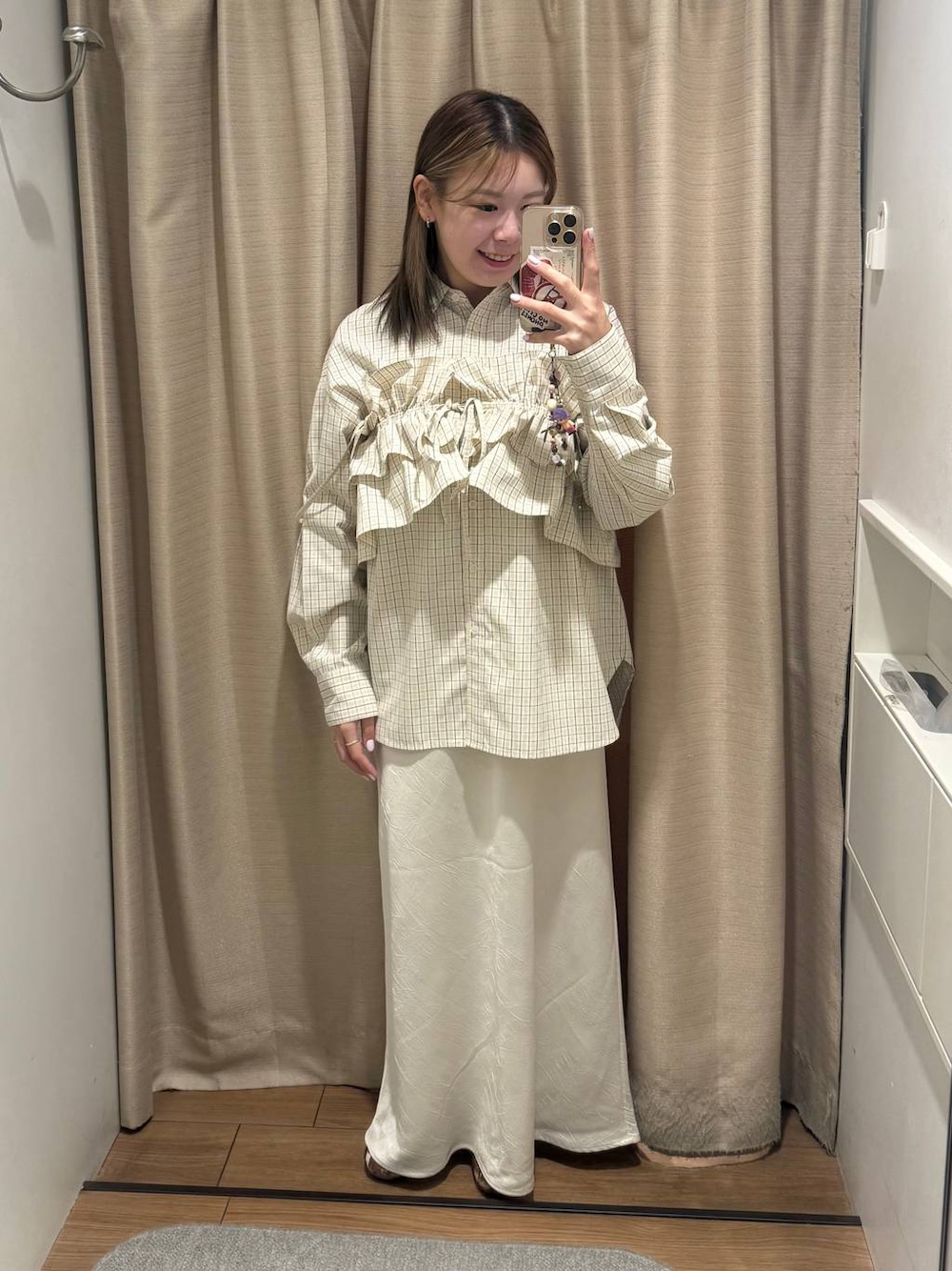 ホワイト系のスカート、ベージュ系のシャツ/ブラウス、ブラウン系のキャミソールを着用したレディースの冬コーディネートの1枚目の写真