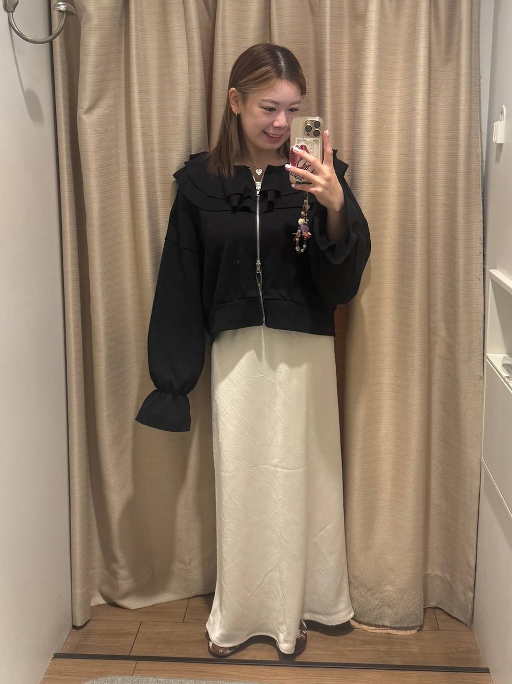 ホワイト系のスカート、ブラック系のスウェットを着用したレディースの冬コーディネートの1枚目の写真