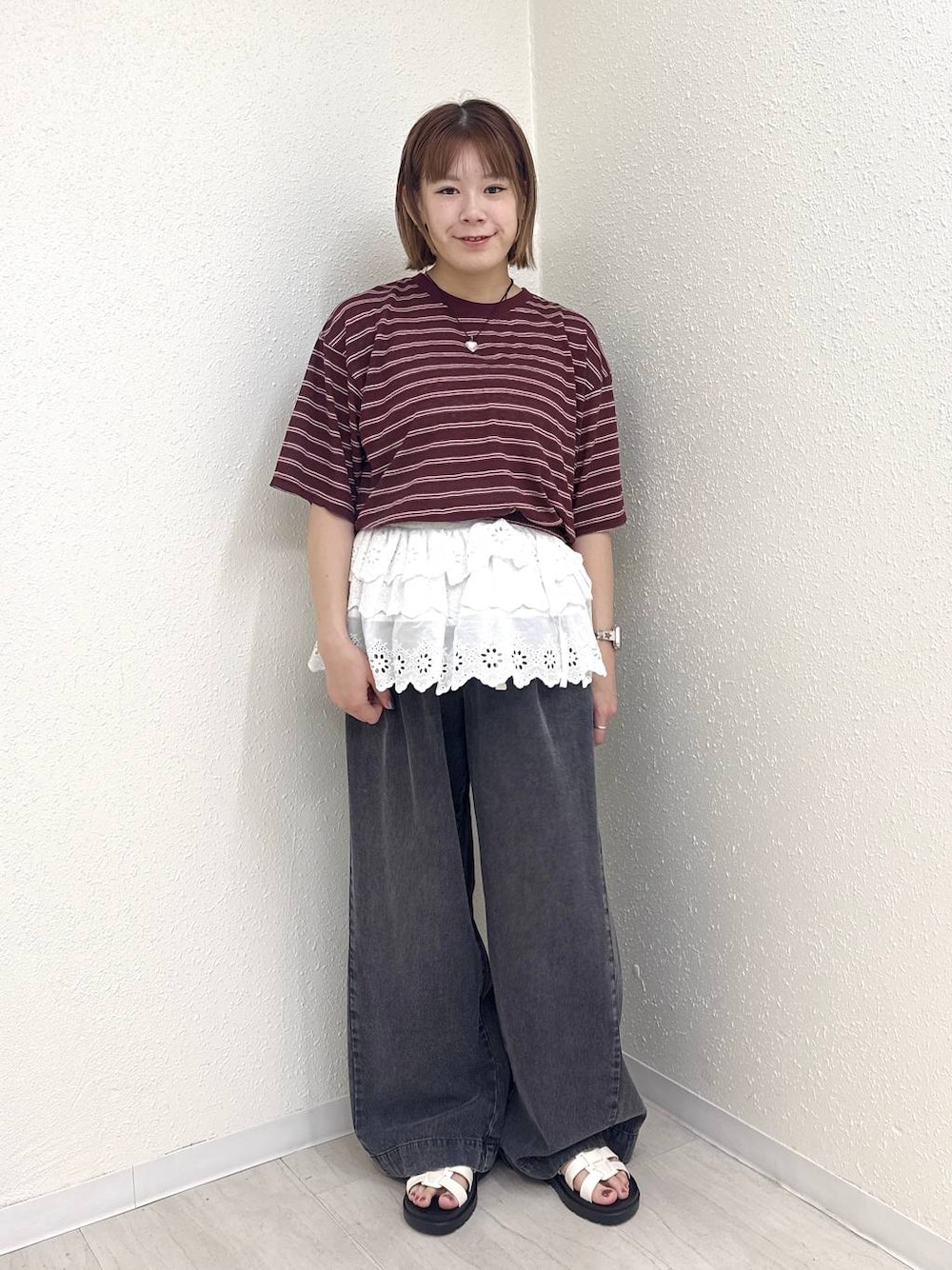 ブラック系のデニムパンツ、ホワイト系のサンダル、ブラウン系のTシャツ/カットソーを着用したレディースの春コーディネートの1枚目の写真