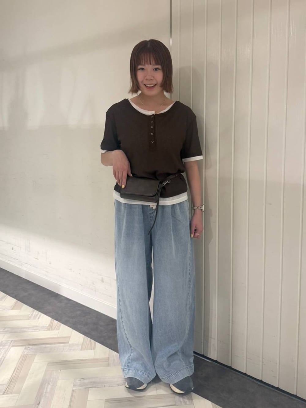 ブルー系のデニムパンツ、ブラウン系のTシャツ/カットソー、ブラウン系のボディバッグ/ウエストポーチを着用したレディースの春コーディネートの1枚目の写真